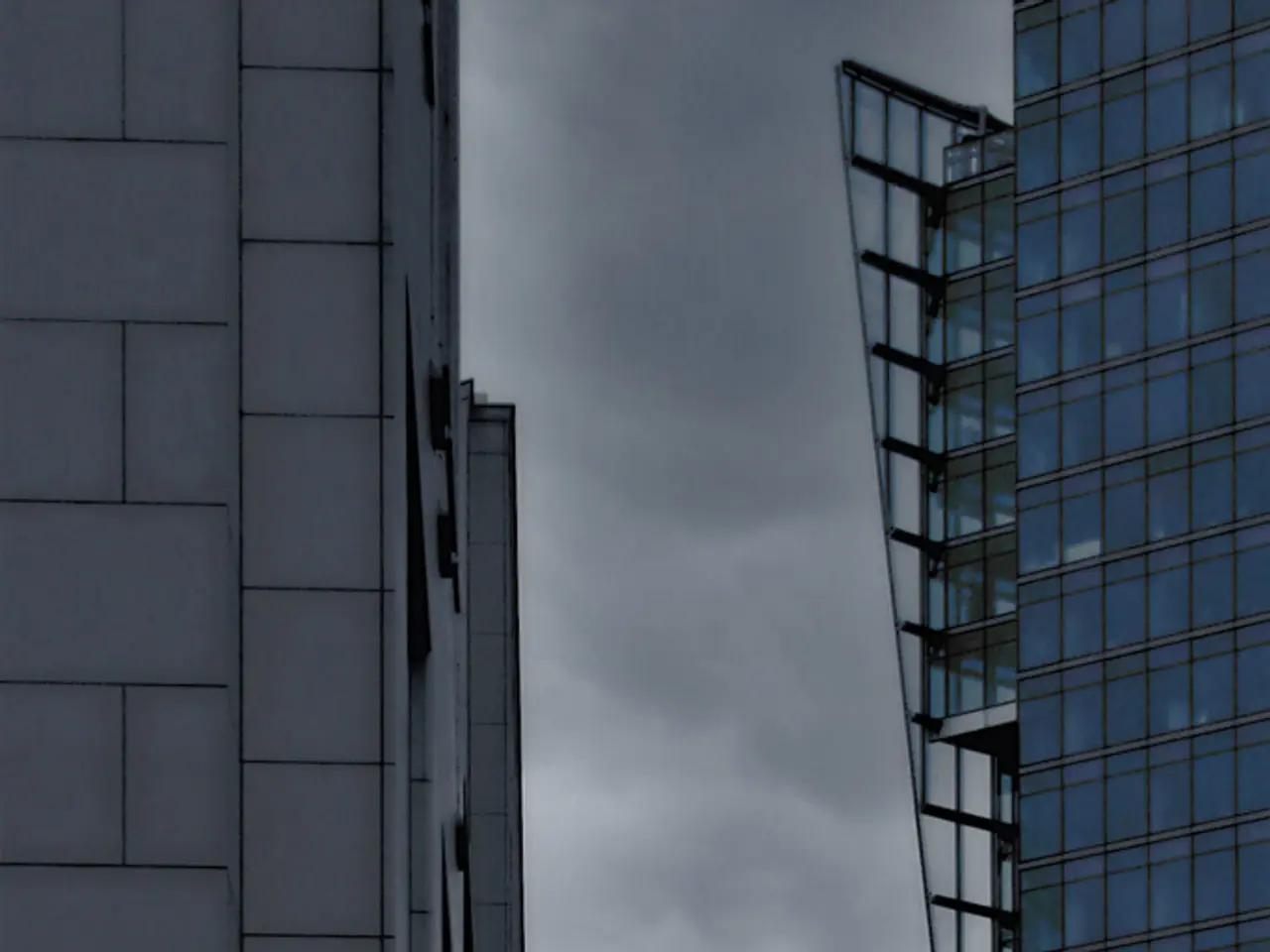 In this image, we can see buildings and in the background, there are clouds in the sky.