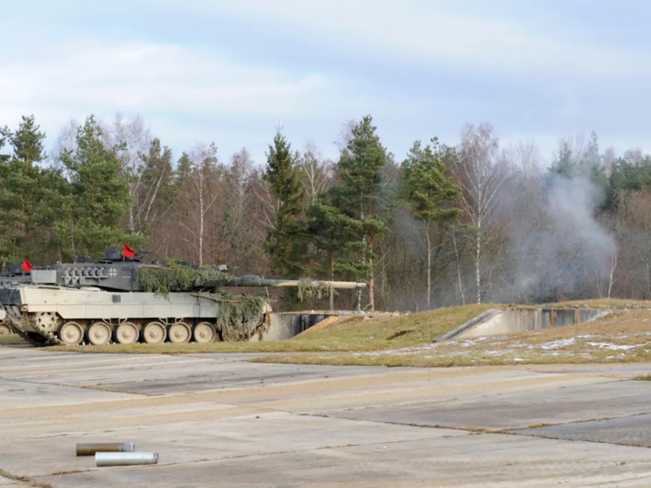 In this picture, we can see a few military tankers, we can see the ground with some objects, grass,...