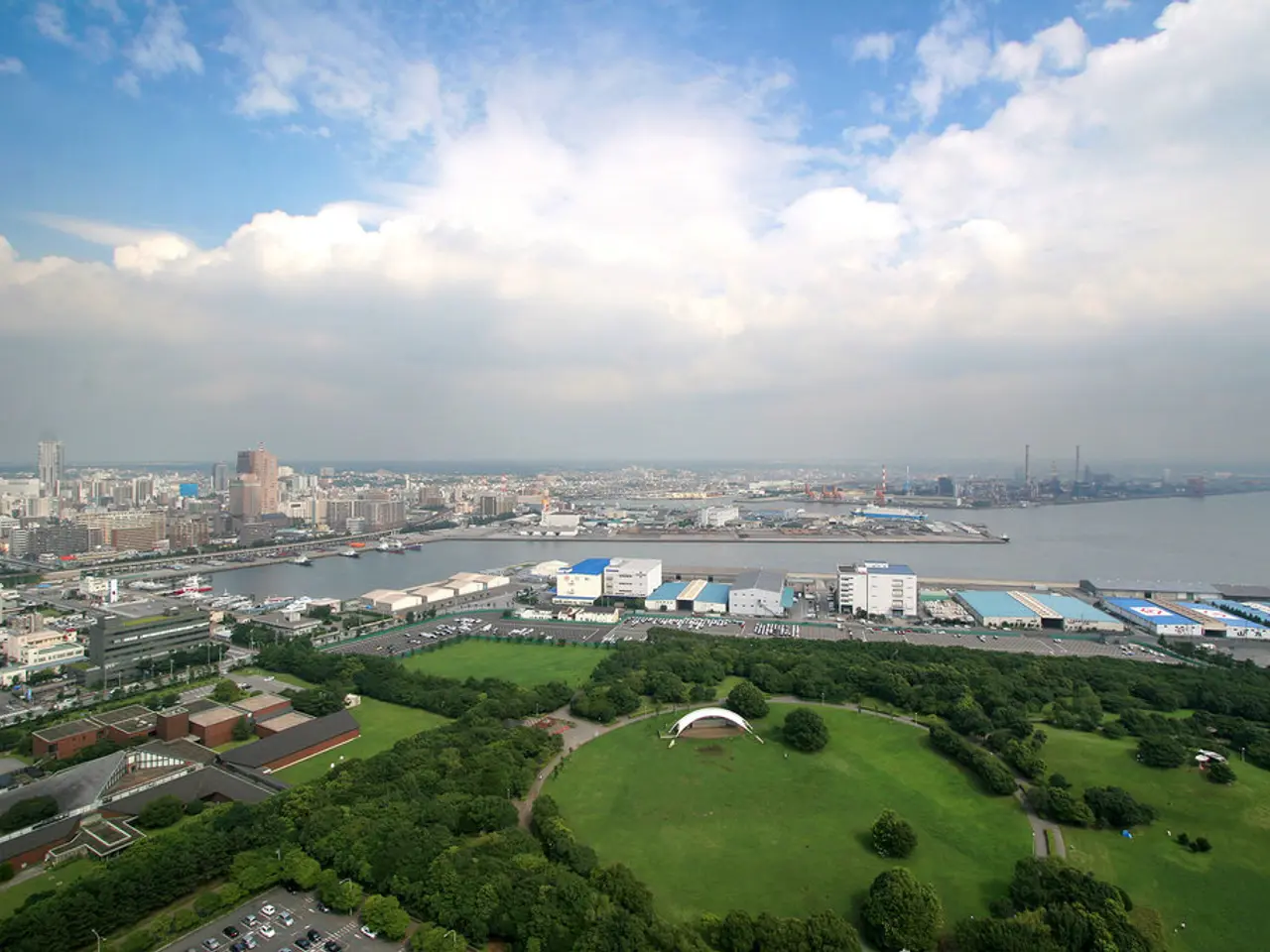 It is an aerial view of the city, there is a huge garden with many trees and around that garden...