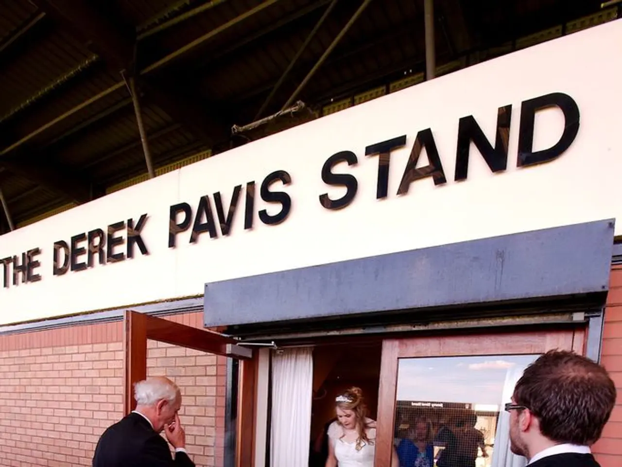 In the foreground of this image, there are two men wearing suits are on the floor. In the...