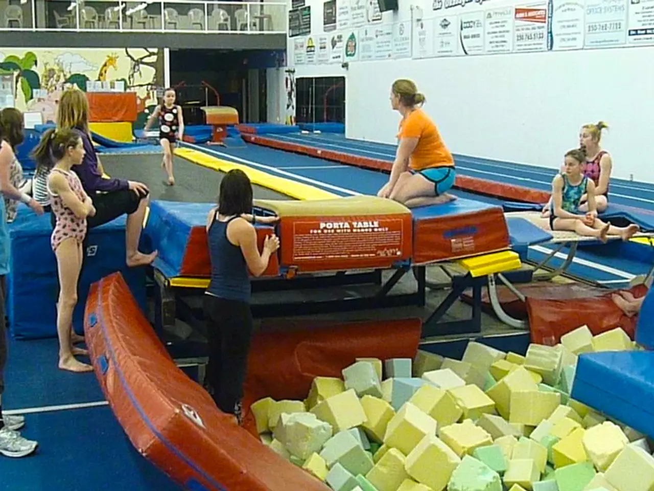 In this image there is a girl walking in a trampoline, around the girl, there are a few people...