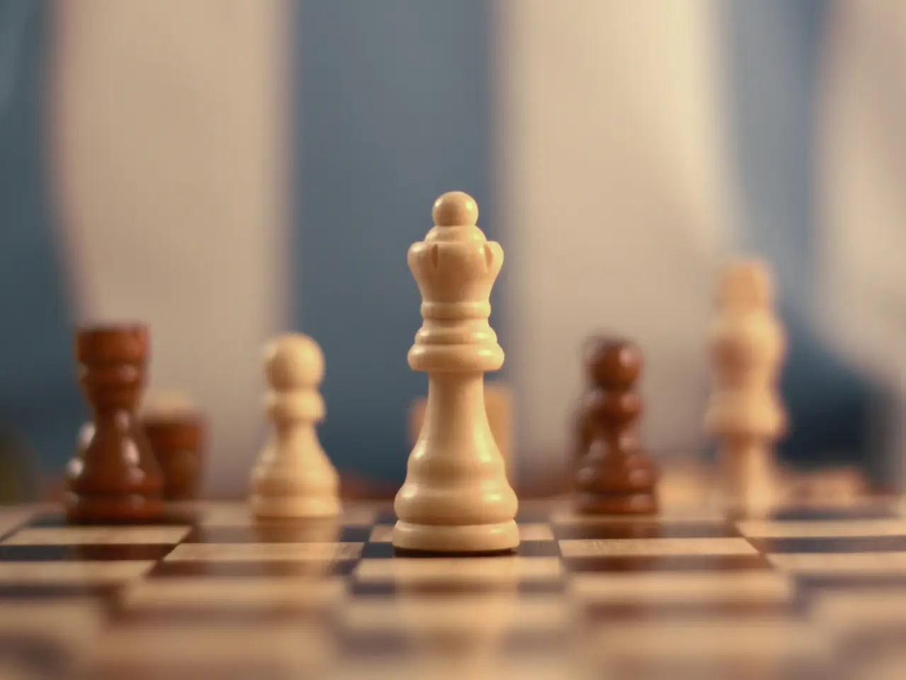 In this image we can see a chess board with chess coins. The background of the image is blur.