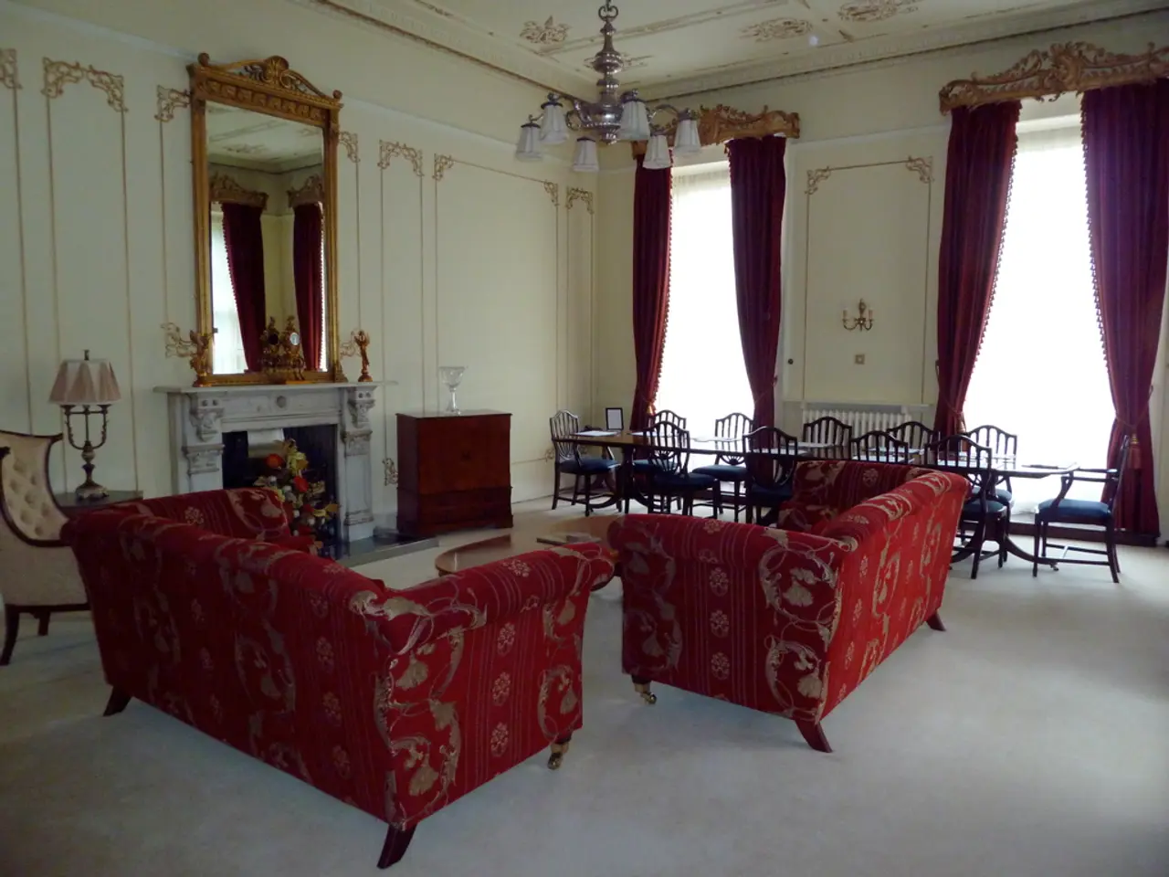This looks like the living room. These are the two red couches. This is a small teapoy with a book...