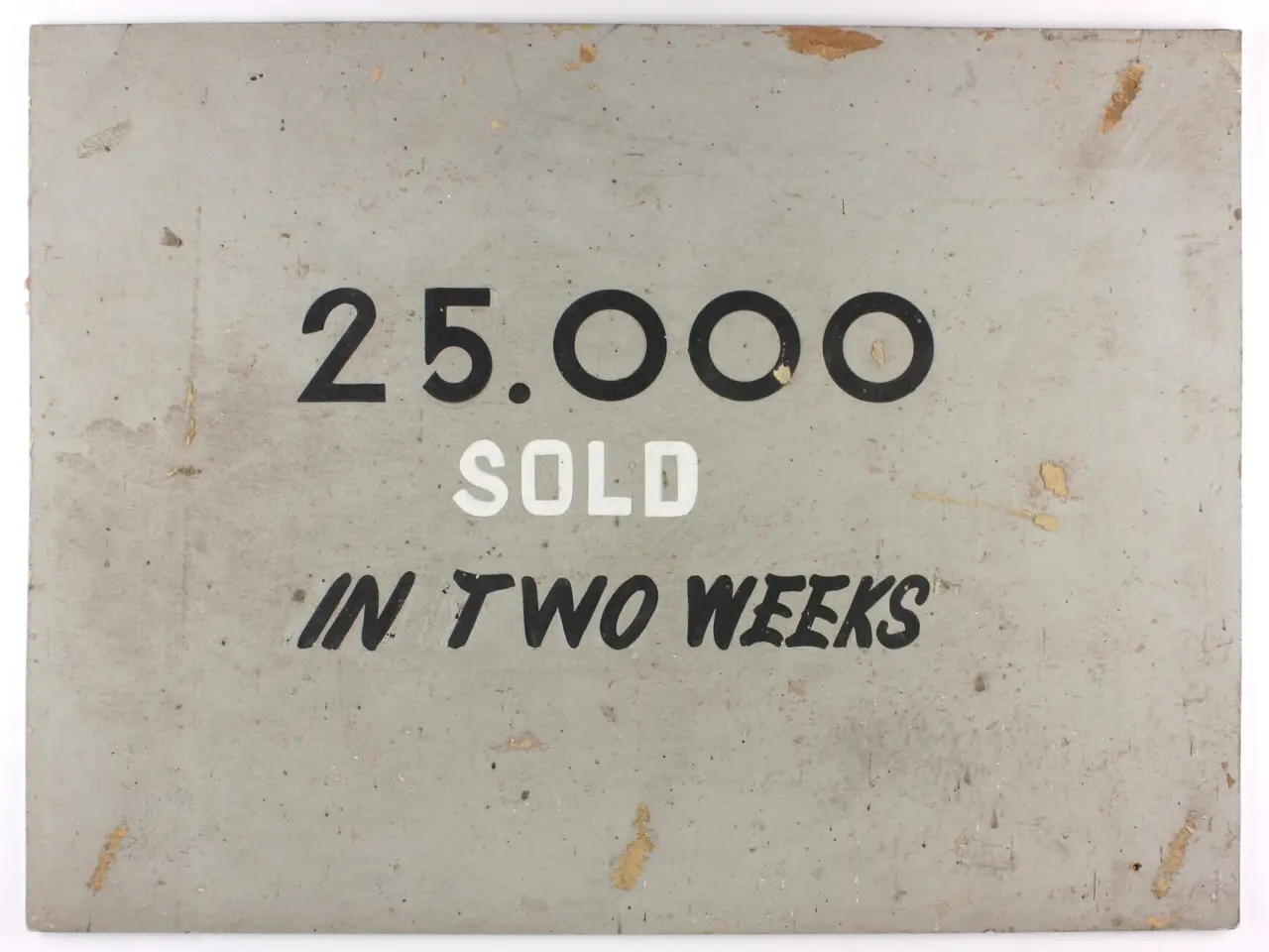 The image shows a white background with a sign that reads "25,000 sold in two weeks" in bold black...