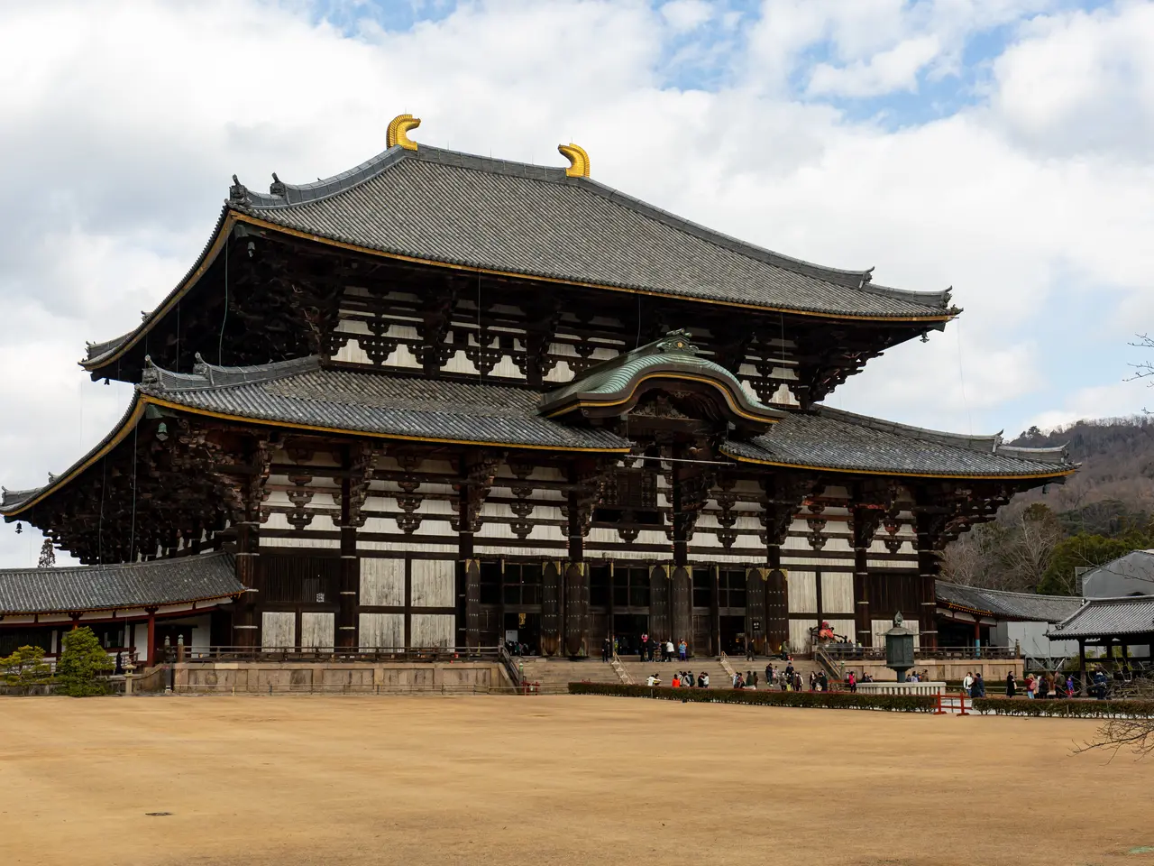 The image shows Todaiji Temple in Nara, Japan. It is a large building with many windows and...