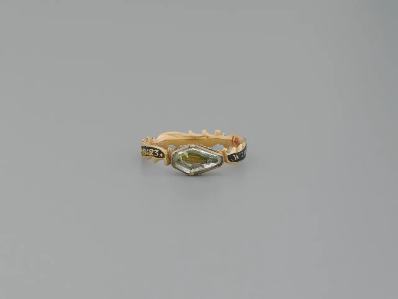 The image shows a gold ring with a marquis cut diamond in the center, surrounded by a halo of...