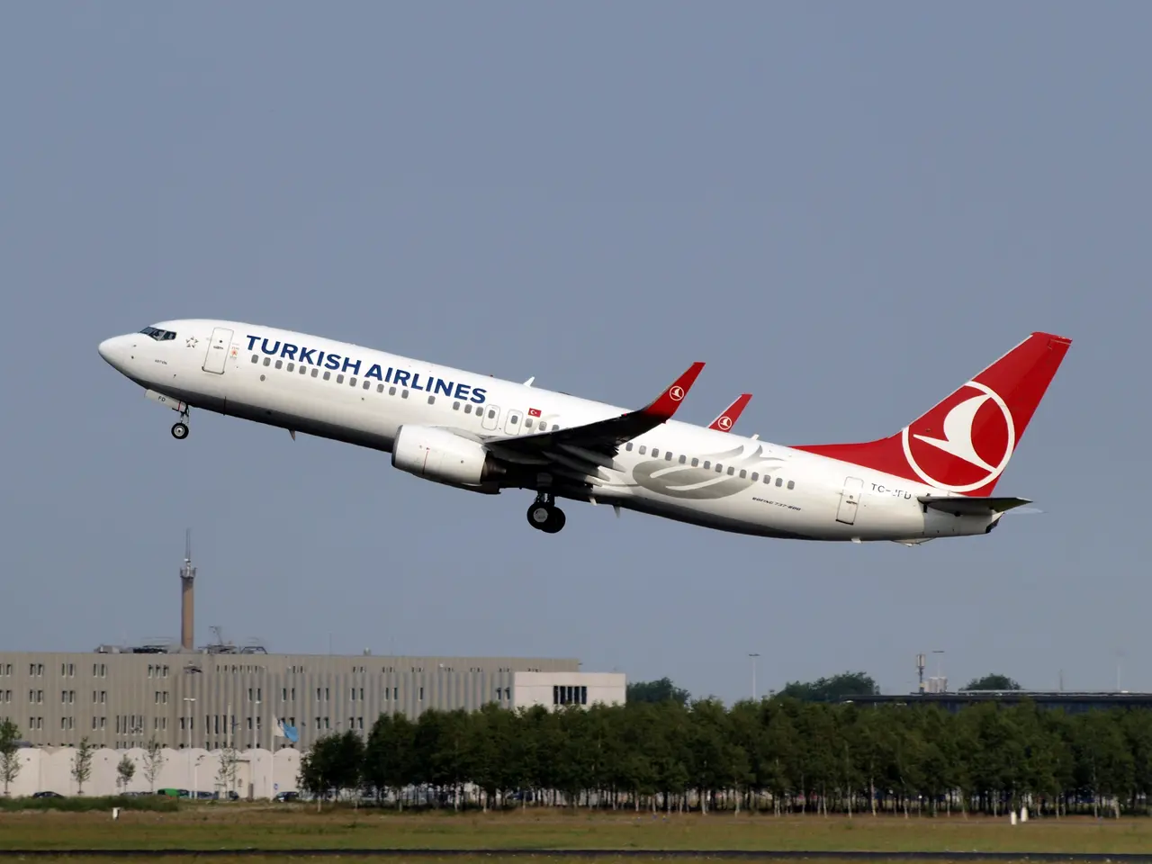 The image shows a Turkish Airlines Airbus A320-200 taking off from Istanbul Airport, with lush...