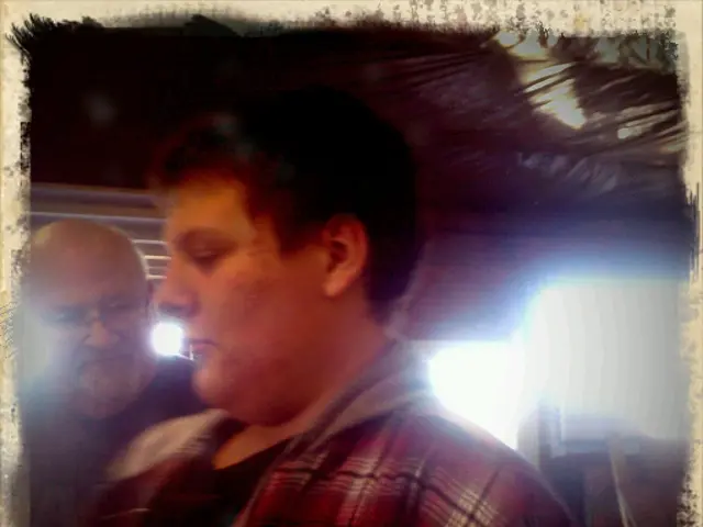 In this image I can see two persons, lights and a rooftop. This image looks like a photo frame.