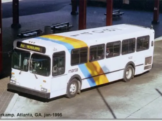 In this image I can see the ground, a bus which is white, orange, yellow, blue and black in color...