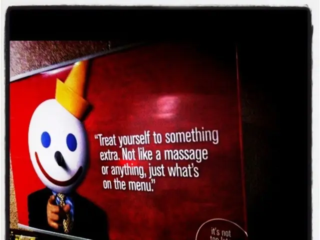 In this image we can see a board placed on the wall. At the bottom there are plants.