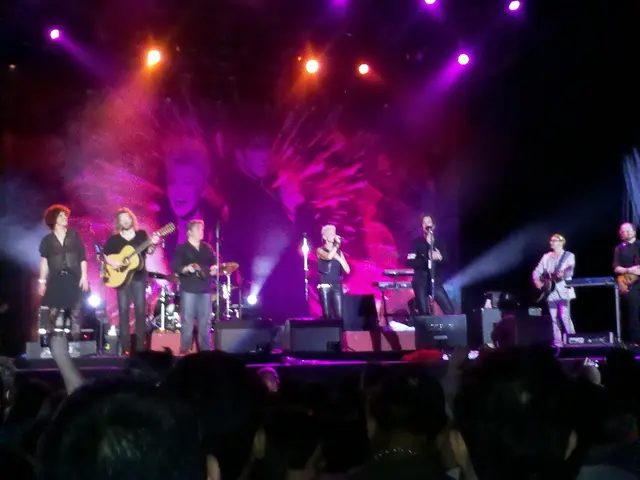 At the top we can see lights. On the background there is a screen. We can see all the persons...