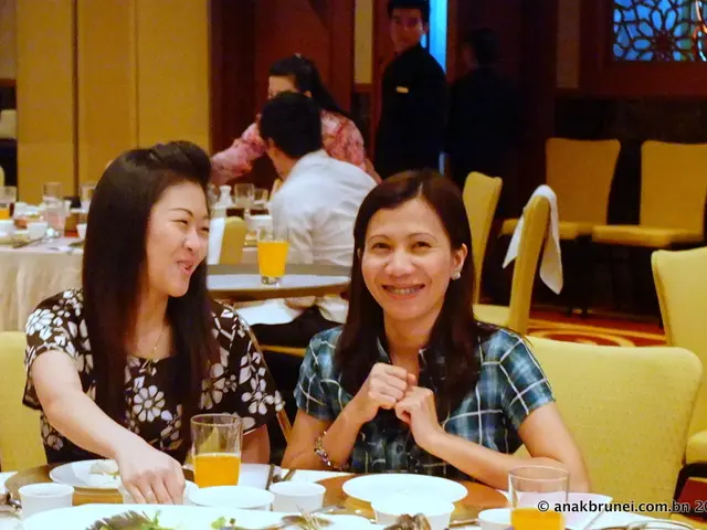 In this image I can see number of people are sitting on chairs. Here on this table I can see few...