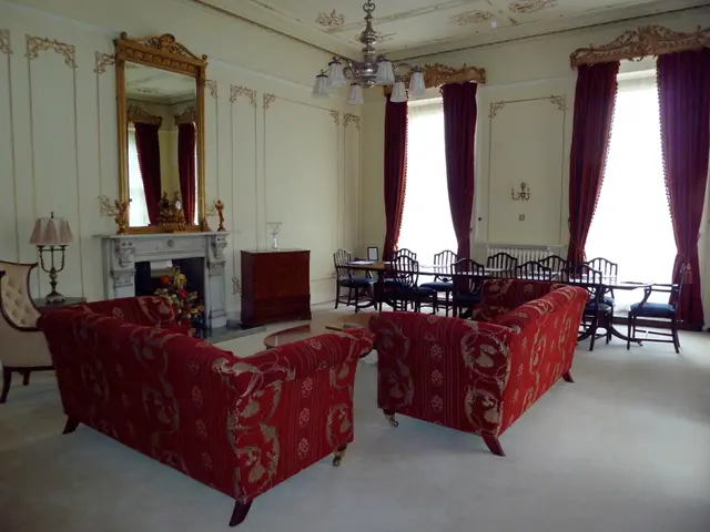 This looks like the living room. These are the two red couches. This is a small teapoy with a book...
