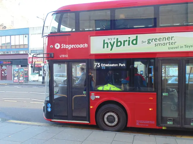 In the foreground of the picture there is payment and a bus. On the left there are buildings,...