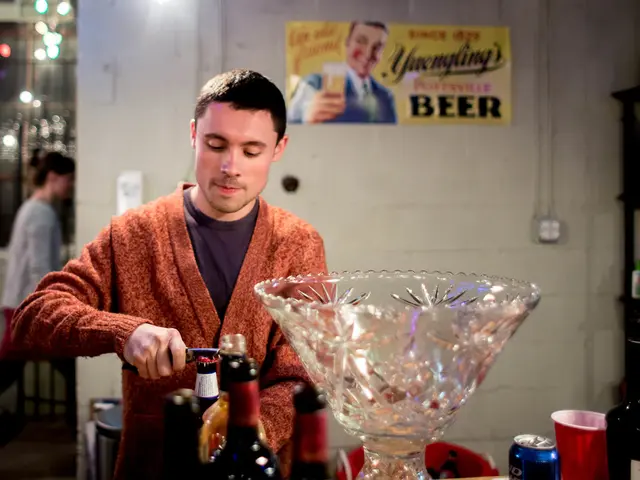 There is a man trying to open bottle cap with opener behind him there is a big glass tray and there...