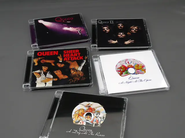 In this image I can see five CD cases. On these I can see some movie posters. Four are in black...