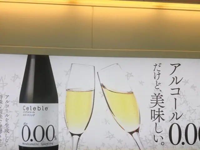 In this picture we can see a poster, on this poster we can see a bottle and glasses with drink in...
