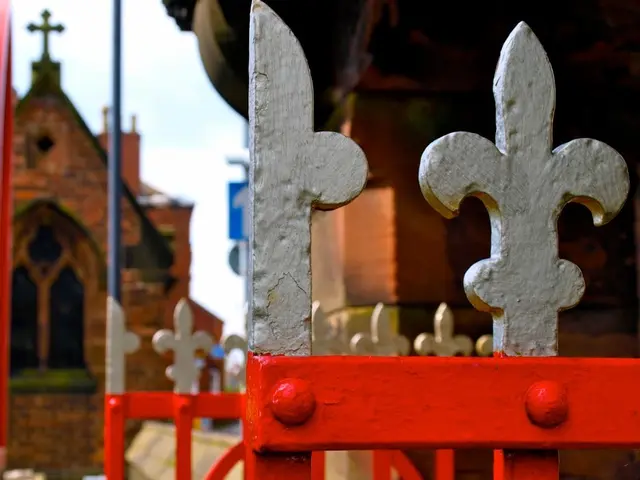 In this image we can see gates. In the back there are buildings. Also there is sky. In the...