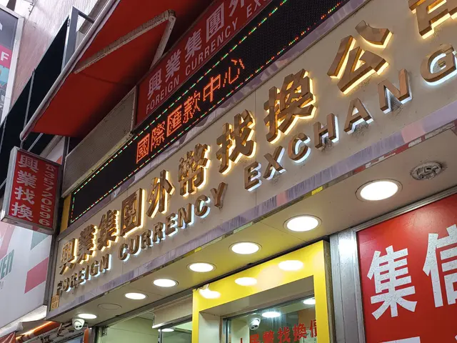 The image shows a foreign currency exchange in Hong Kong, with a store front featuring a sign that...