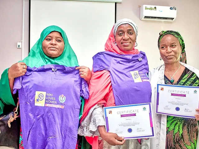 The image shows three women standing next to each other, each holding up a certificate. The woman...