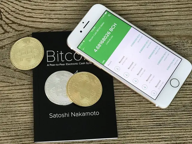 The image shows a wooden table with a book and a mobile phone sitting on top of it, next to a pile...