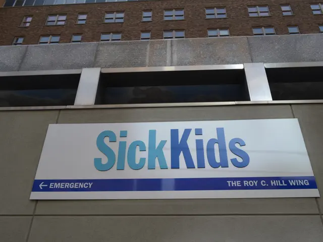 The image shows a building with a sign that reads "Sick Kids" on the side of it. The building has...