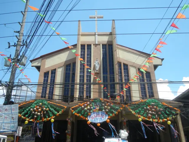 The image shows a large building with a cross on top of it, surrounded by vehicles on the road,...