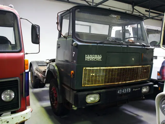 The image shows a group of trucks parked next to each other in a garage, with a wall in the...