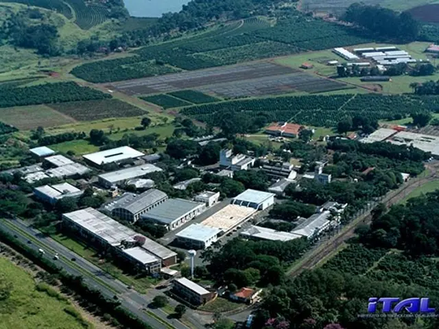 The image shows an aerial view of a large industrial area in the middle of a field, surrounded by...
