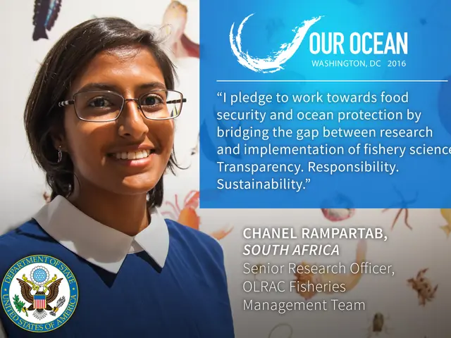 The image shows a woman in a blue shirt and glasses smiling at the camera. On the right side of the...