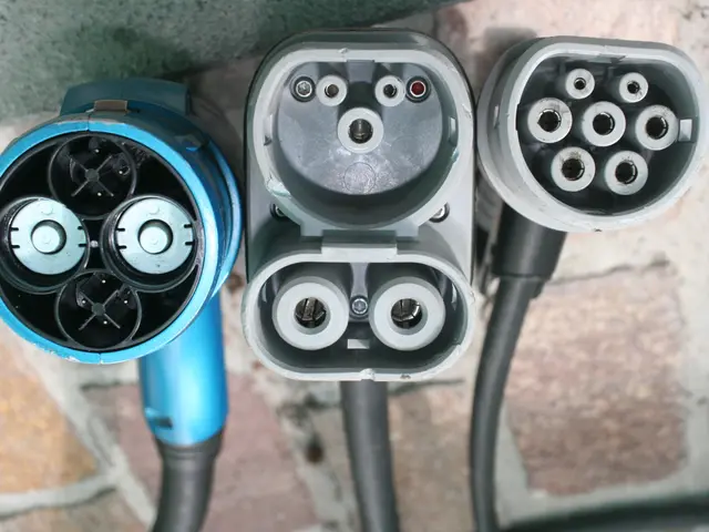 The image shows an electric vehicle charging station with two blue and black cables connected to...