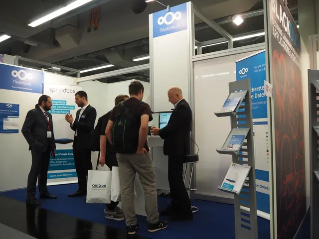 The image shows a group of people standing in front of a booth at a trade show, with some of them...