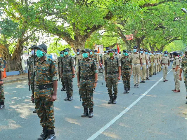 The image shows a group of police officers wearing uniforms, caps, and masks walking down a street...