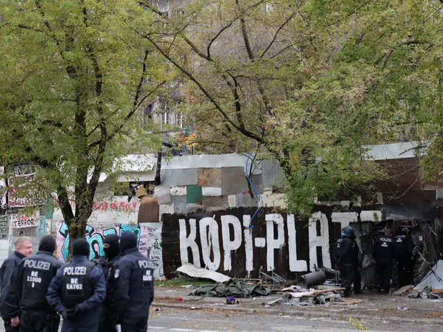 The image shows a group of police officers standing in front of a building with graffiti on it....