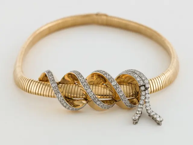 The image shows a stunning 18k yellow gold and diamond bangle bracelet with a twisted design. The...