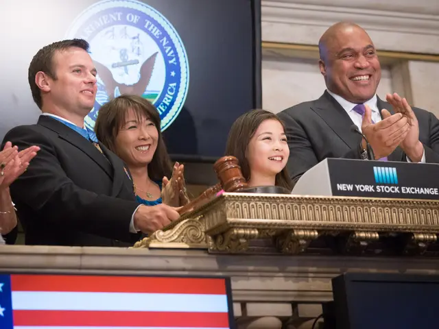 The image shows a group of people standing around a podium in front of an American flag, clapping...