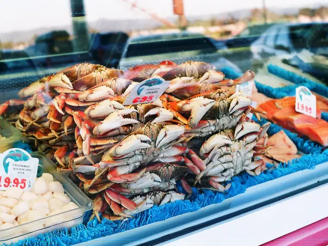 The image shows a display case filled with lots of different types of seafood, including crabs,...