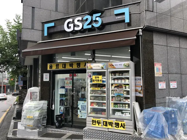 The image shows a building with a sign that reads "GS25" on the side of it, surrounded by vehicles...