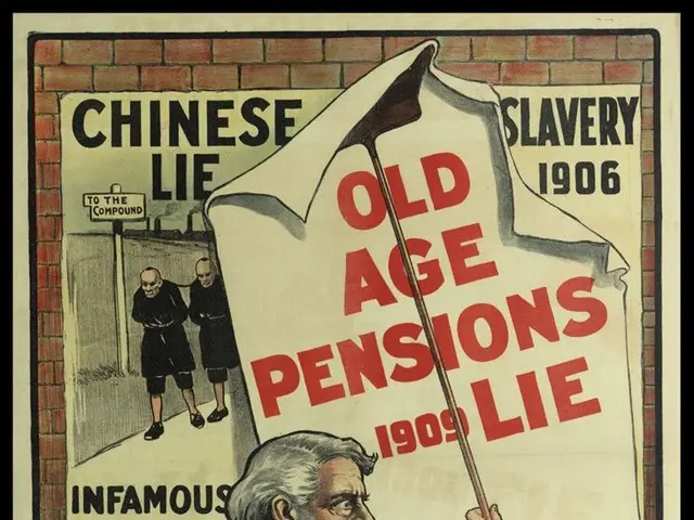 The image shows a poster on a brick wall with a man holding a sign that reads "Chinese Slavery: Old...